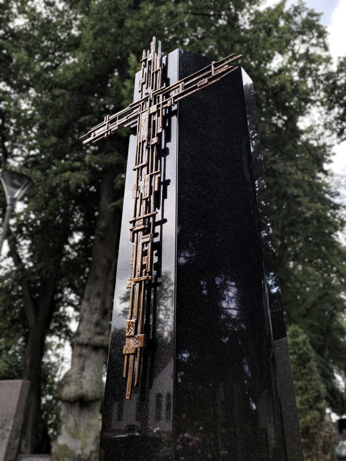 Czarny słupek granitowy i miedziany krzyż